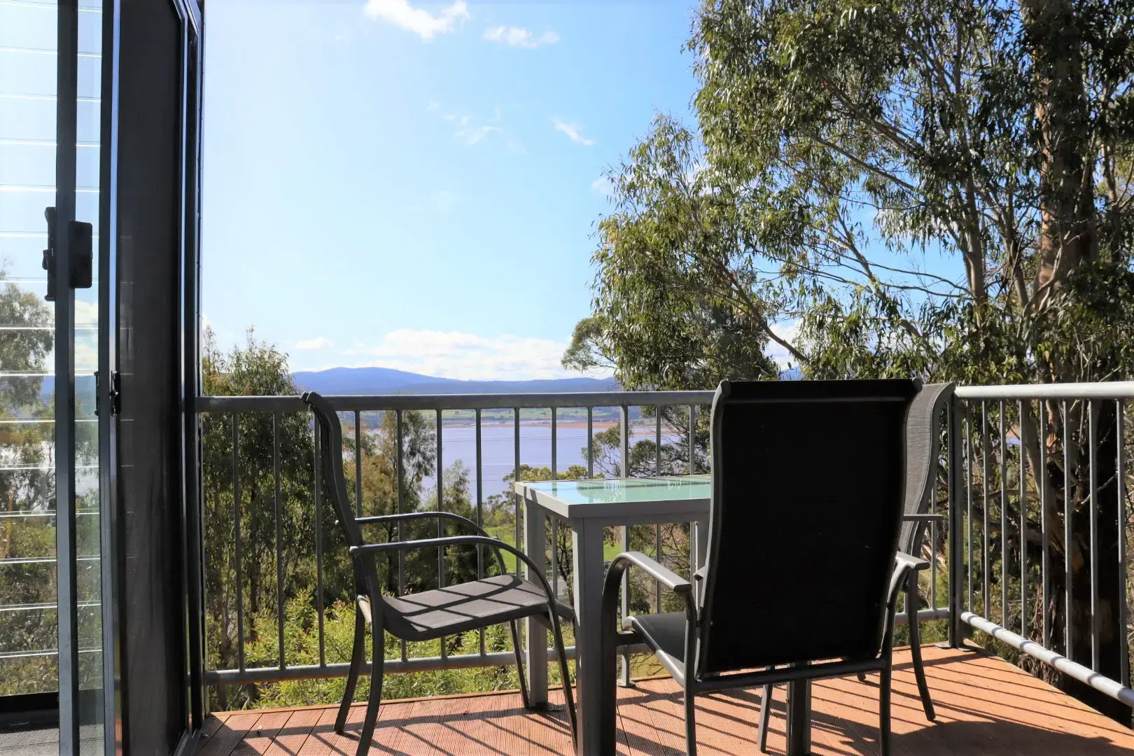 Balcony with chairs overlooking river and mountains