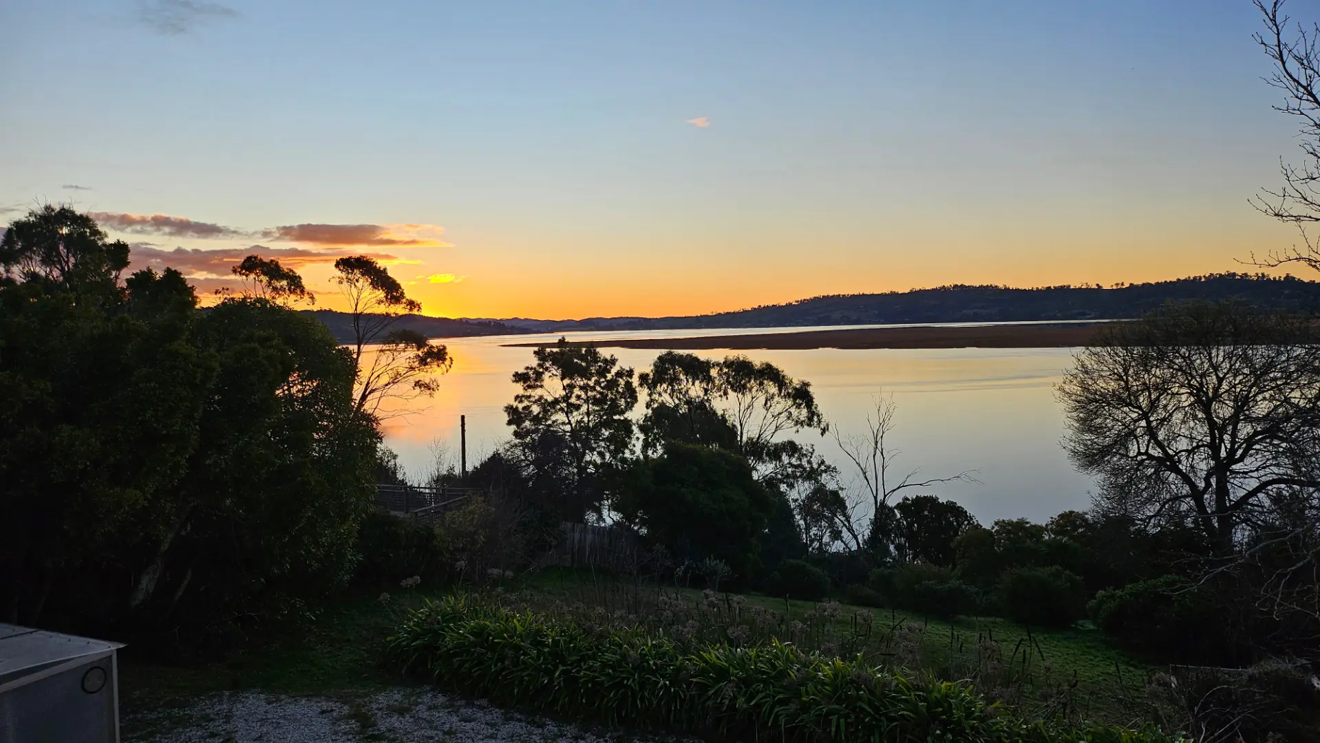 Serene sunset over calm water and trees