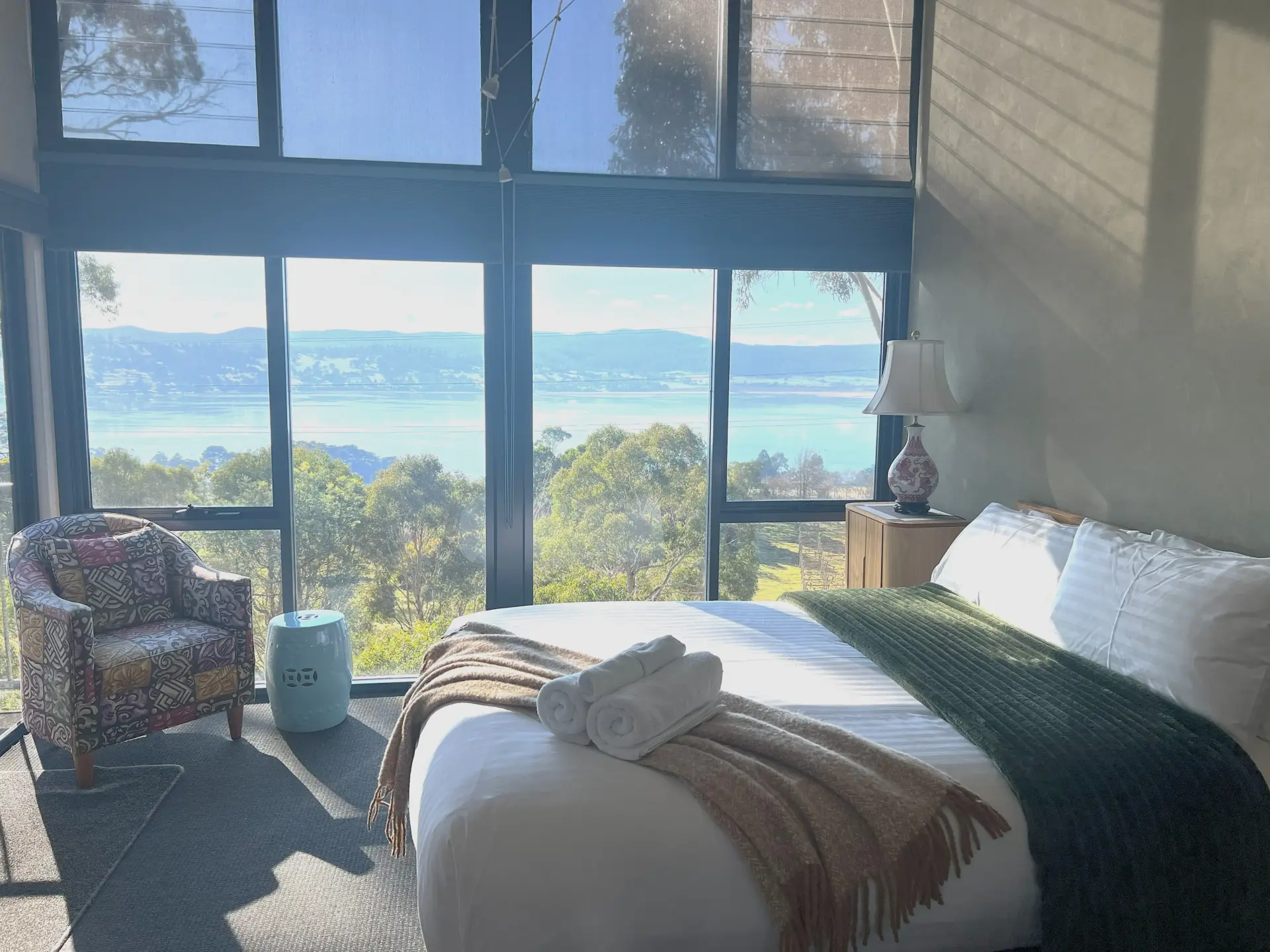 Sunlit bedroom with water and bushland views