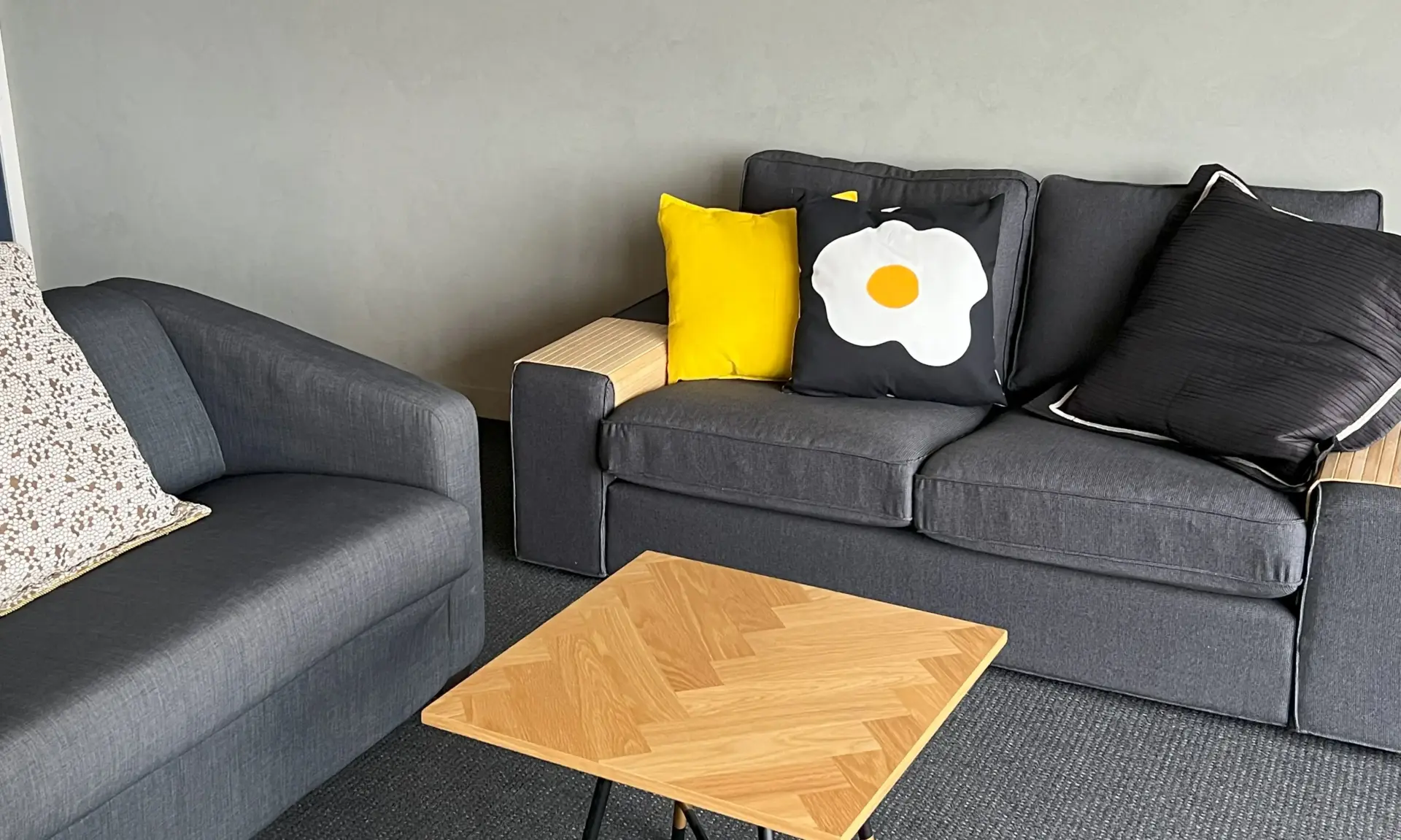Modern grey sofas with yellow cushions and wooden table