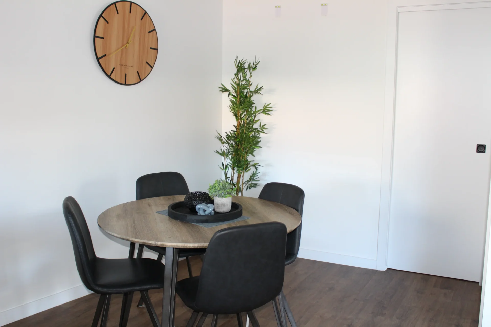 Modern dining area with plants and clock.