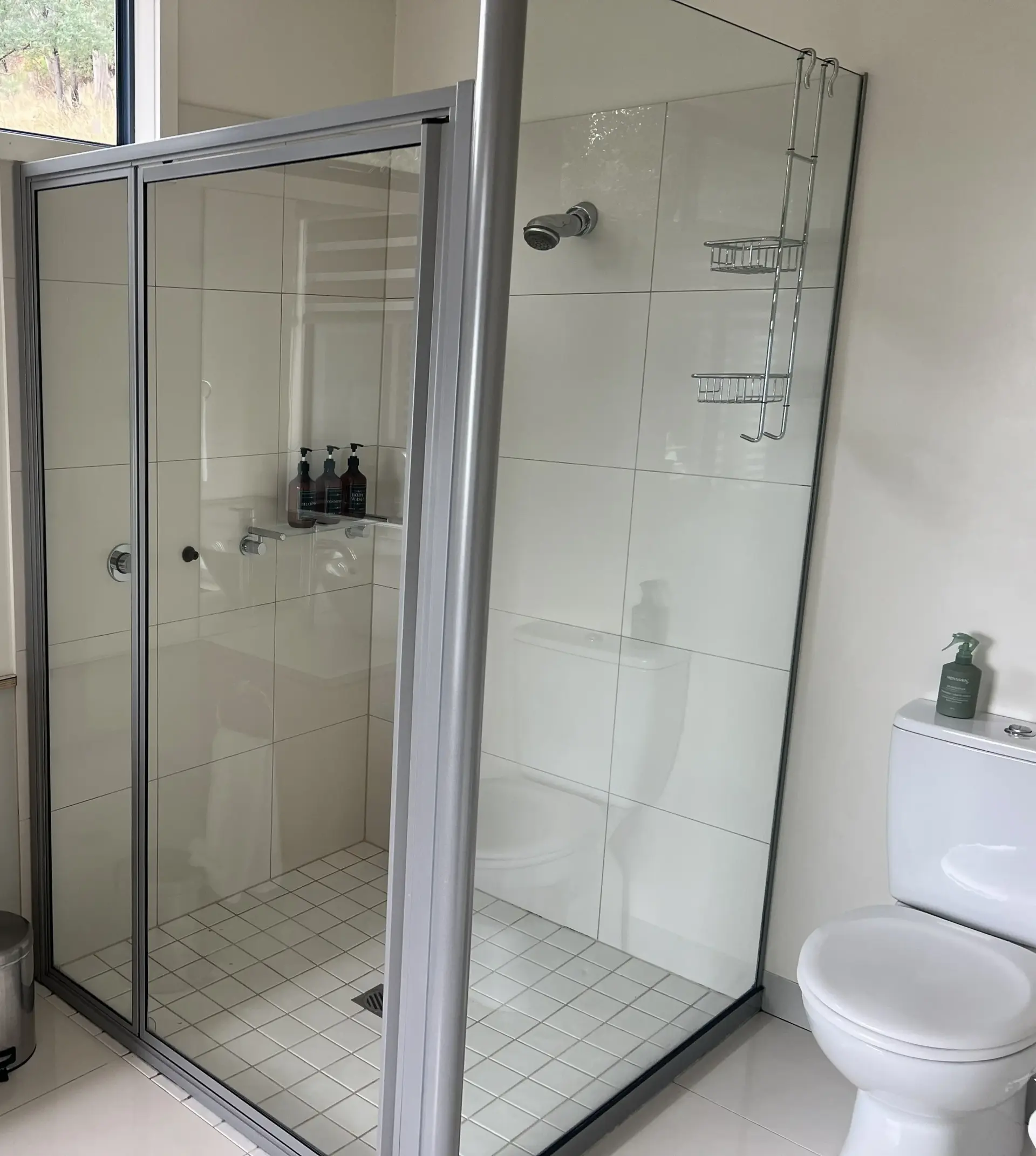 Modern bathroom with glass shower and white tiles