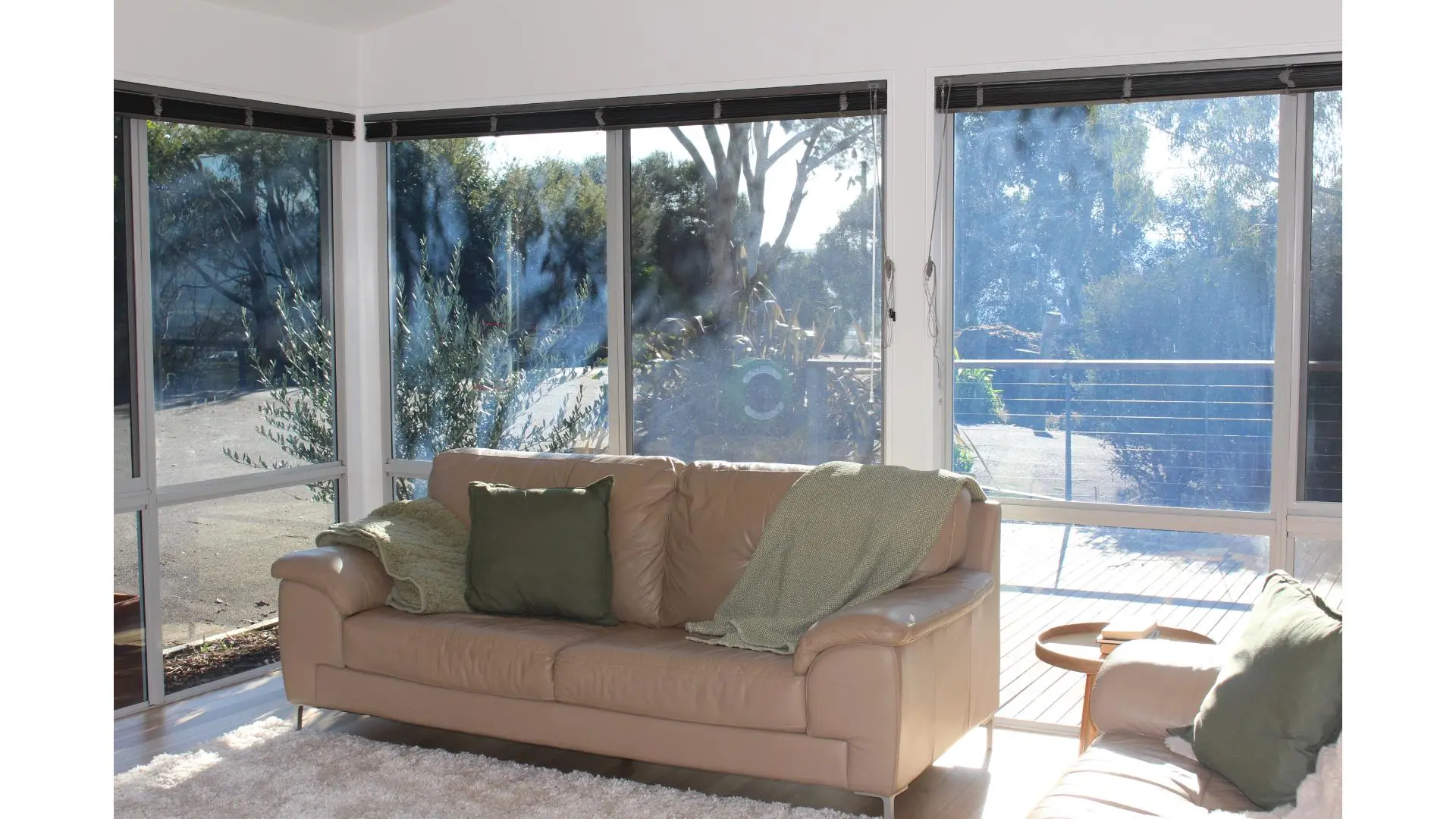 Cosy lounge area with sunlight and greenery outside.