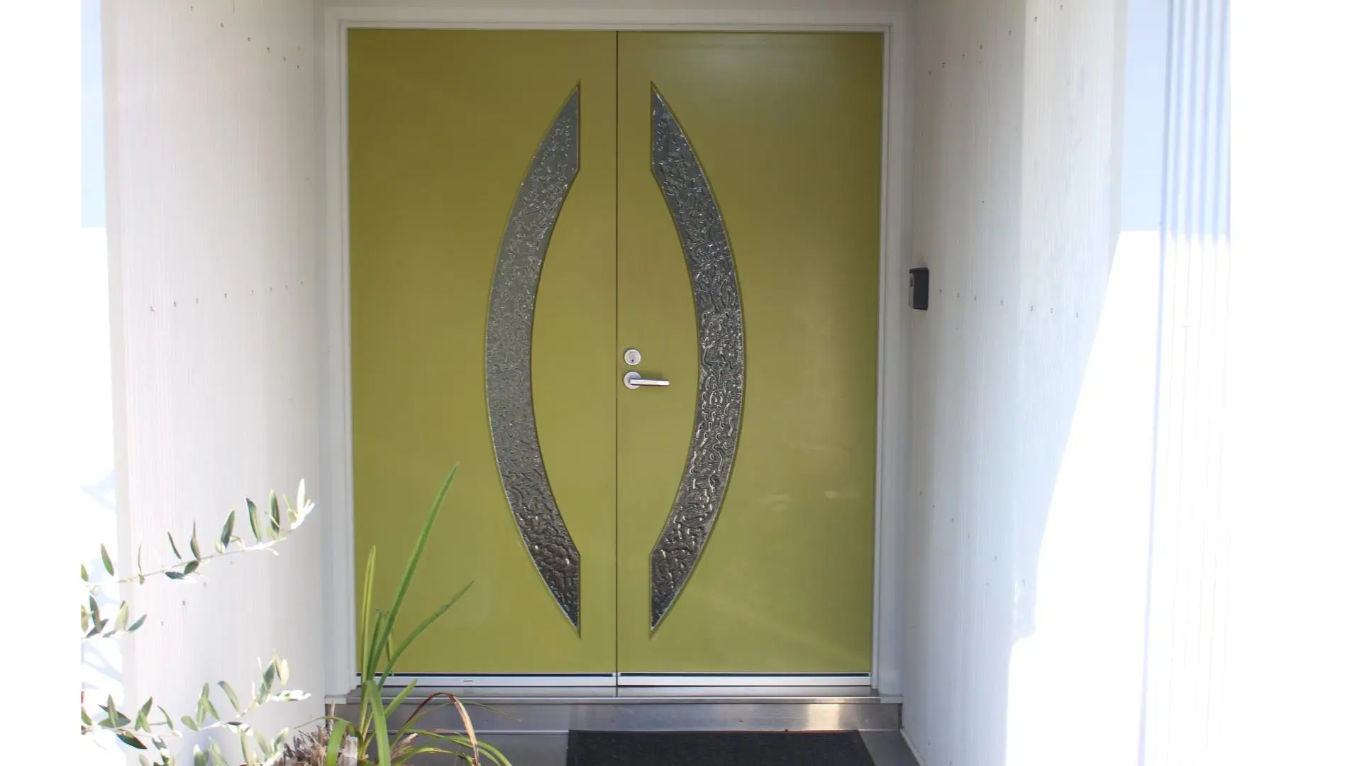 Vibrant green front door with decorative glass.