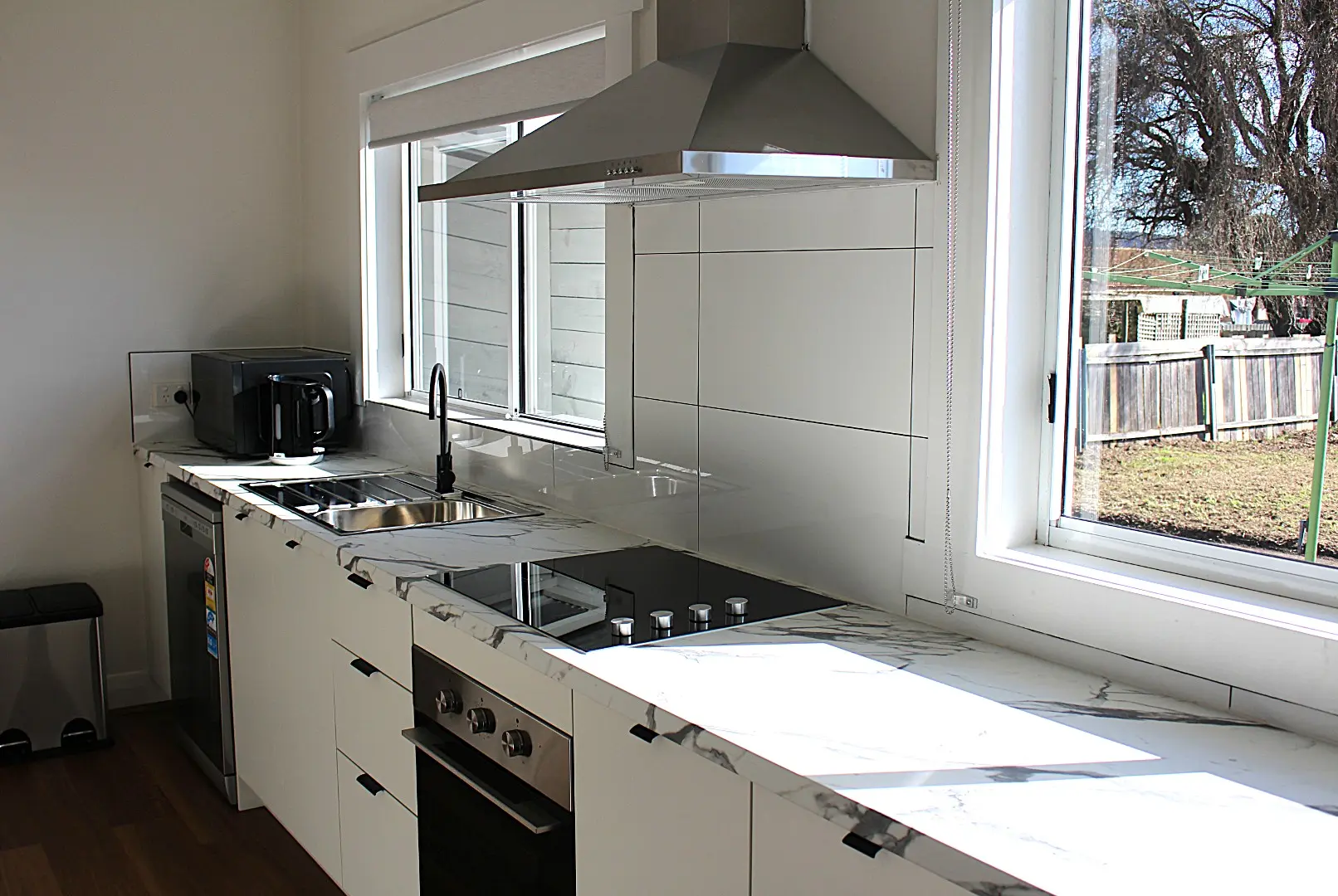 Modern kitchen with marble countertops and bright lighting.