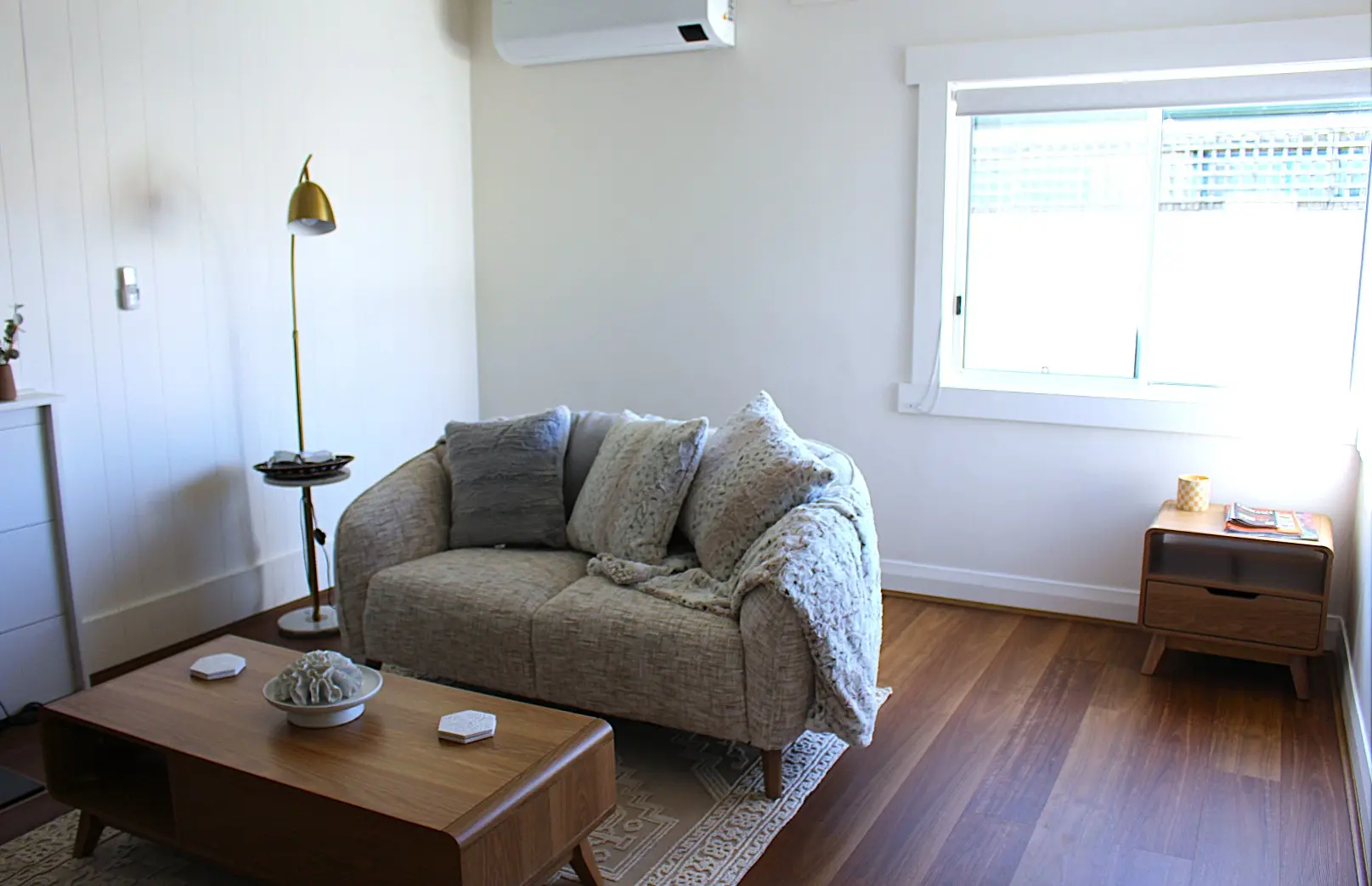 Cozy living room with sofa and wooden furniture.