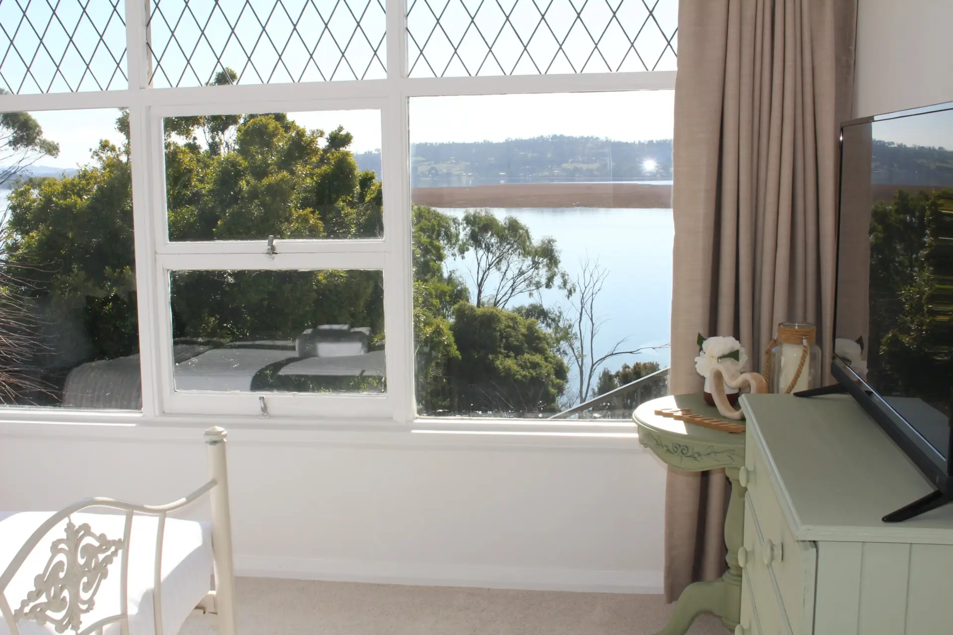 Bright room with a view of calm water.