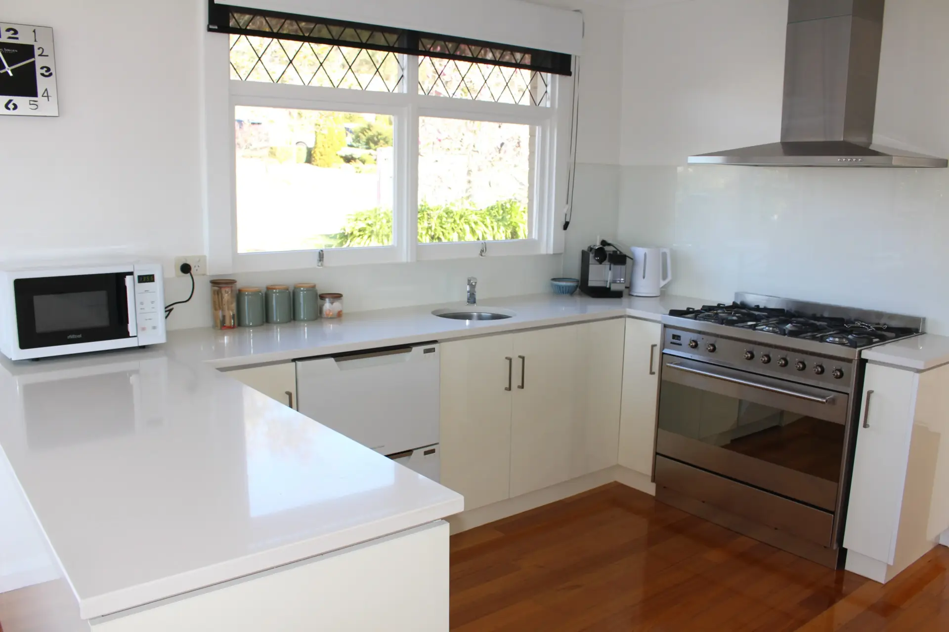 Modern kitchen with stainless steel appliances and windows.