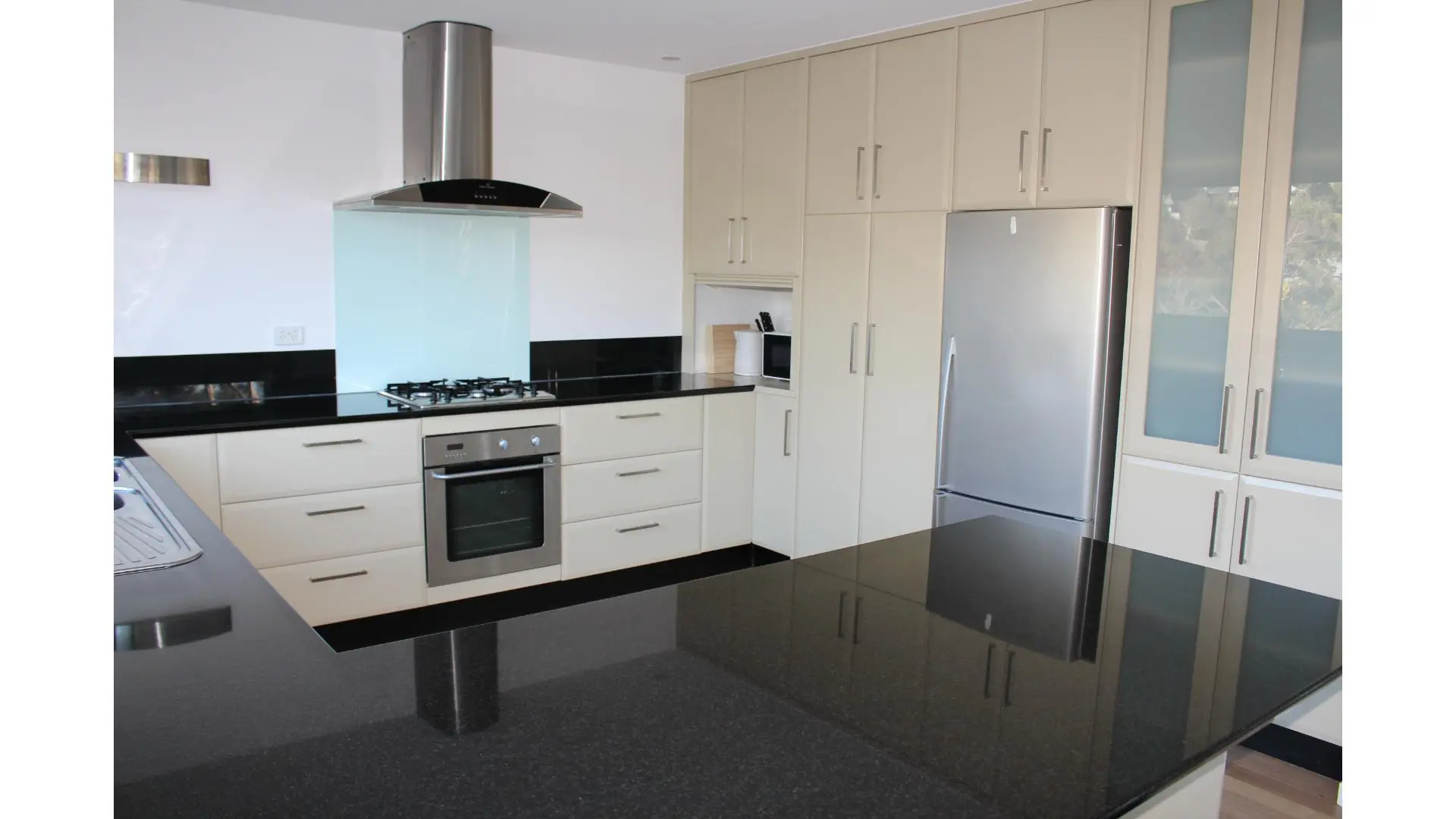 Modern kitchen with black countertops and appliances