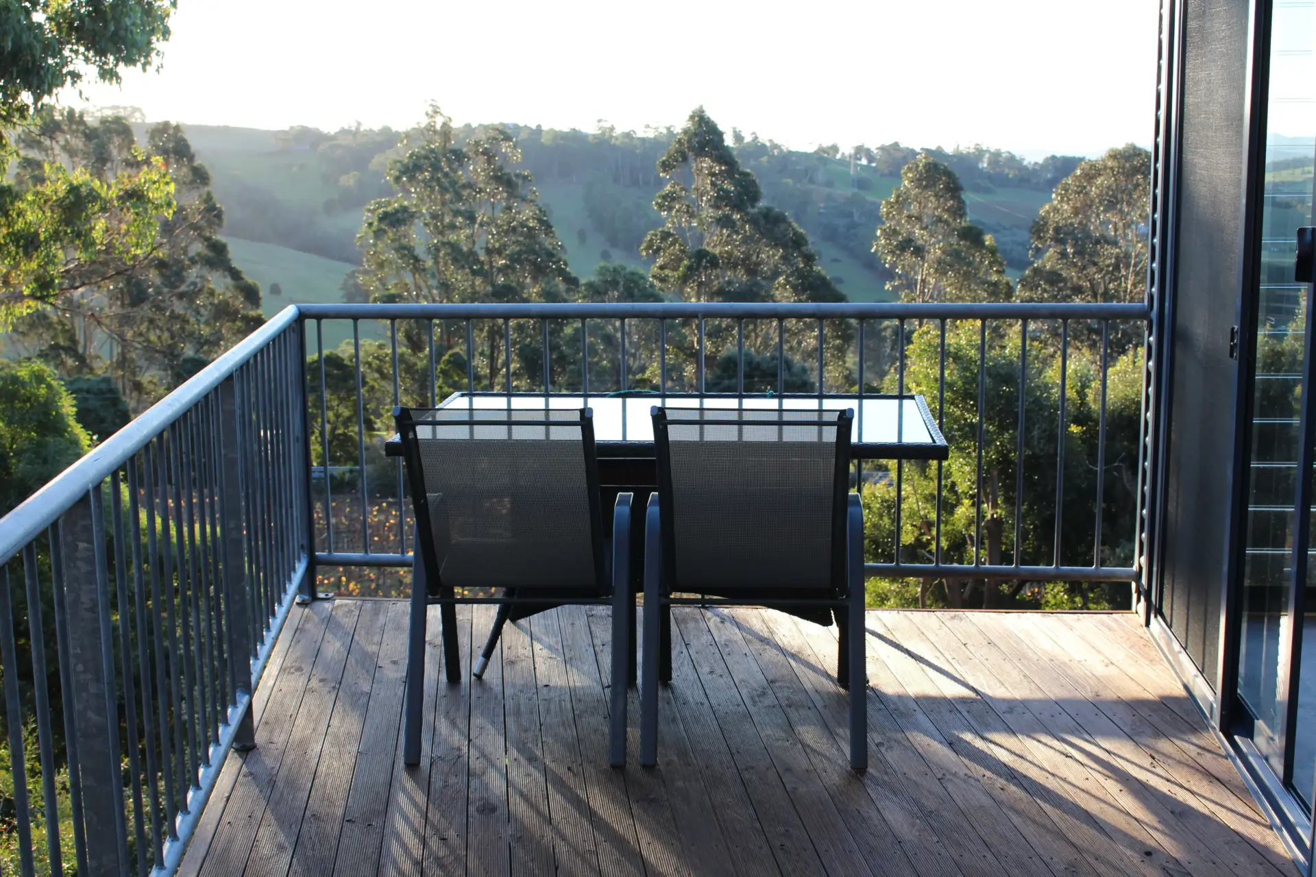 Balcony table and chairs overlooking green hills