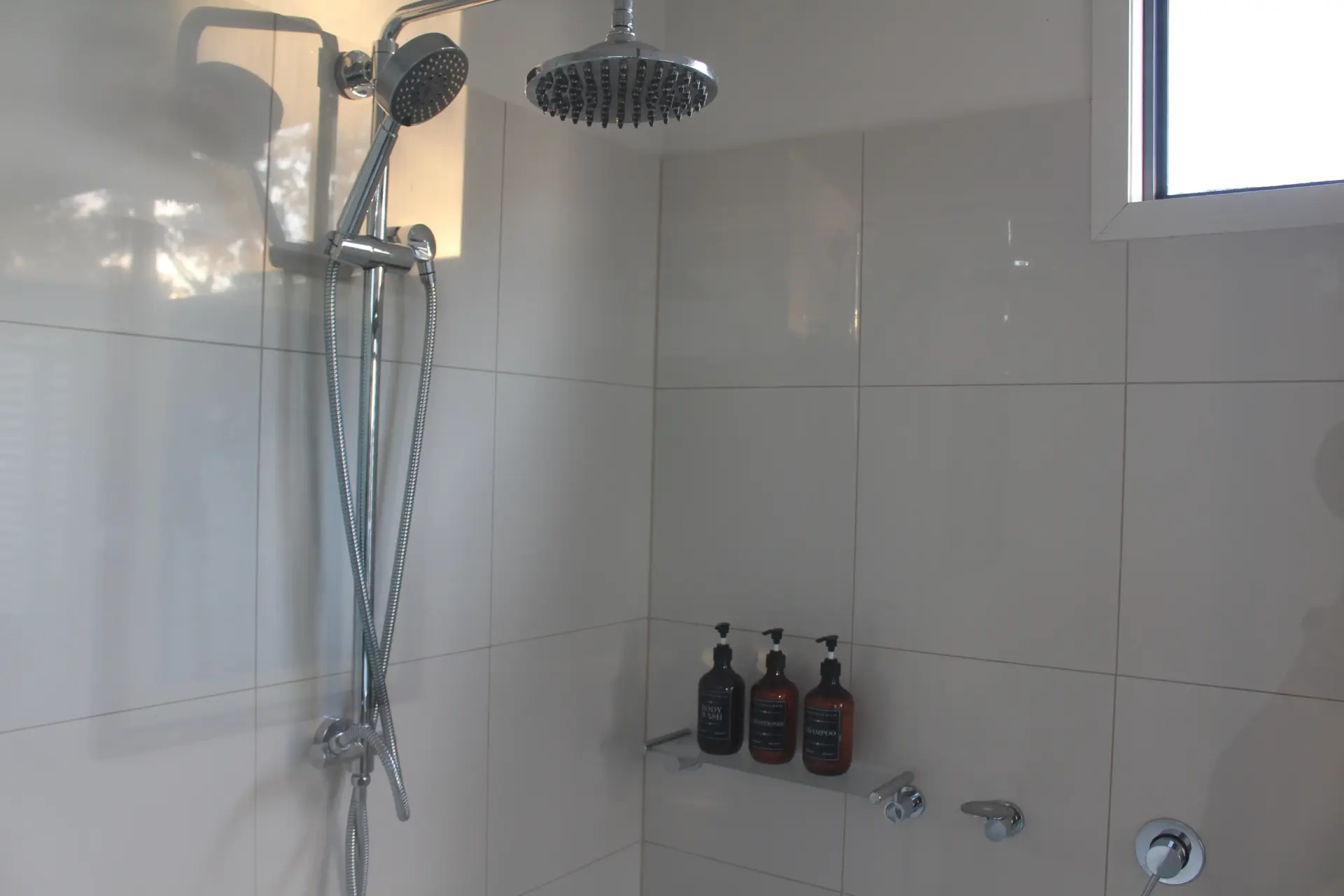 Modern tiled shower with rainfall and handheld heads