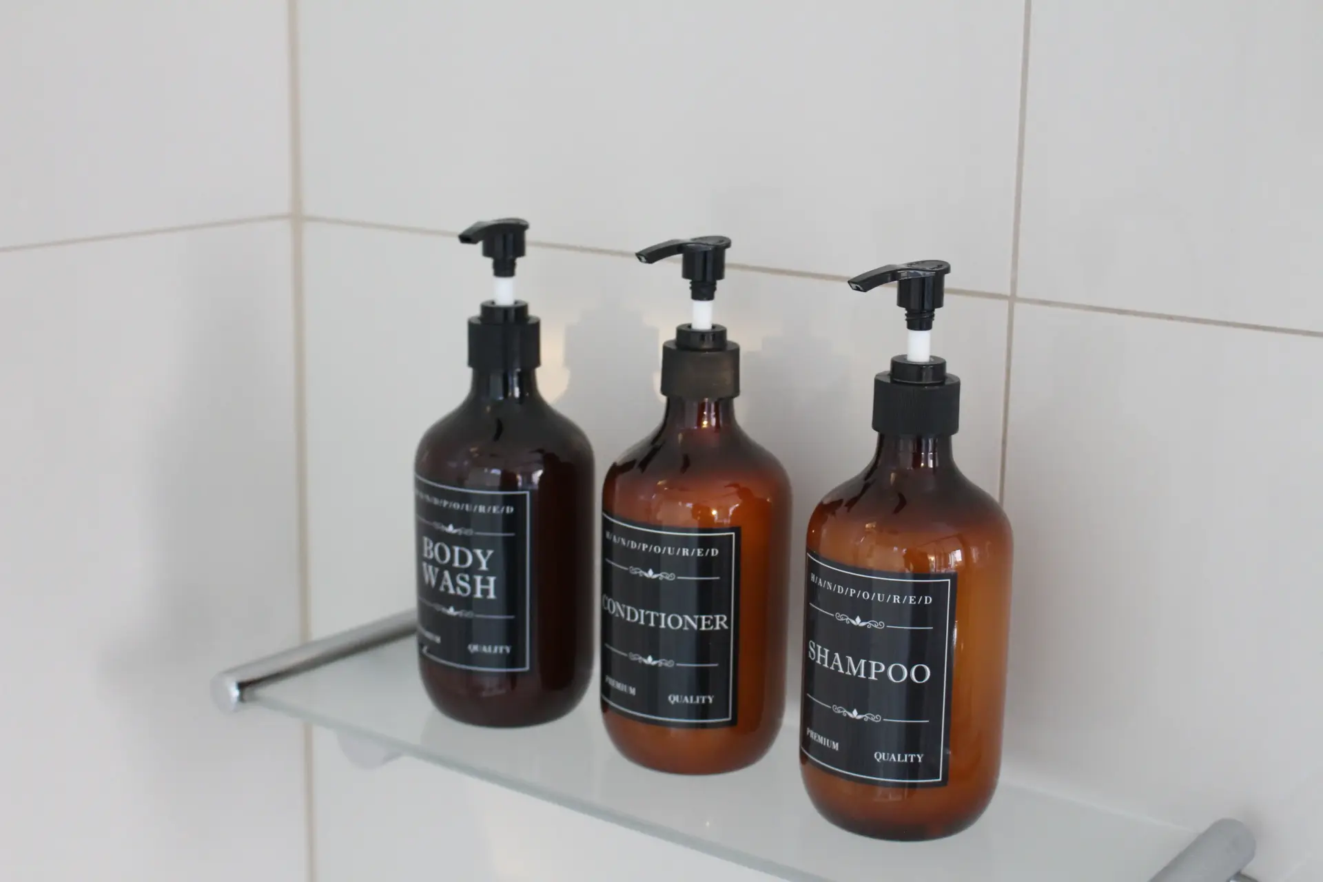 Amber pump bottles on bathroom shelf