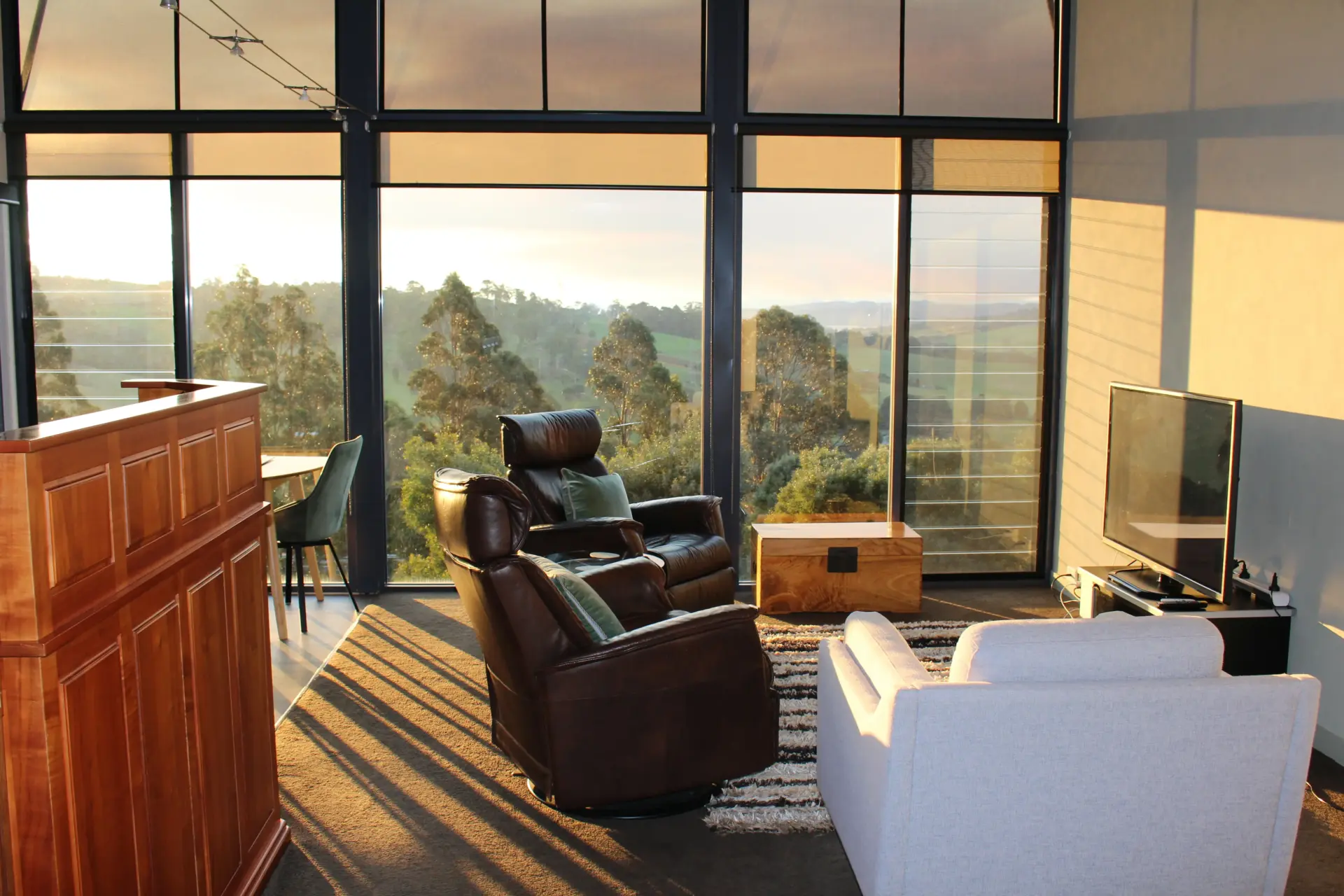 Modern living room with panoramic bushland sunset views