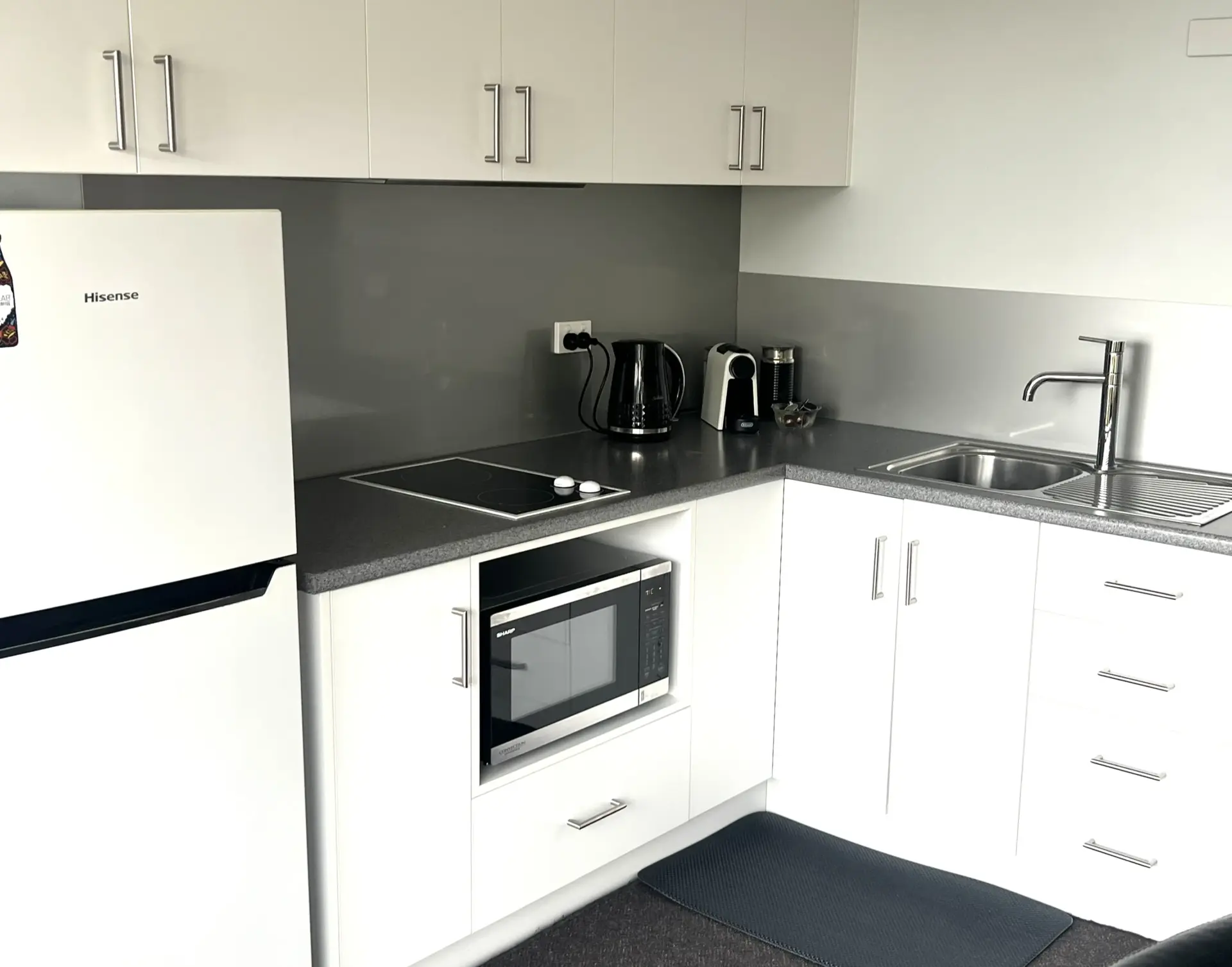 Modern white kitchen with grey benchtop and appliances