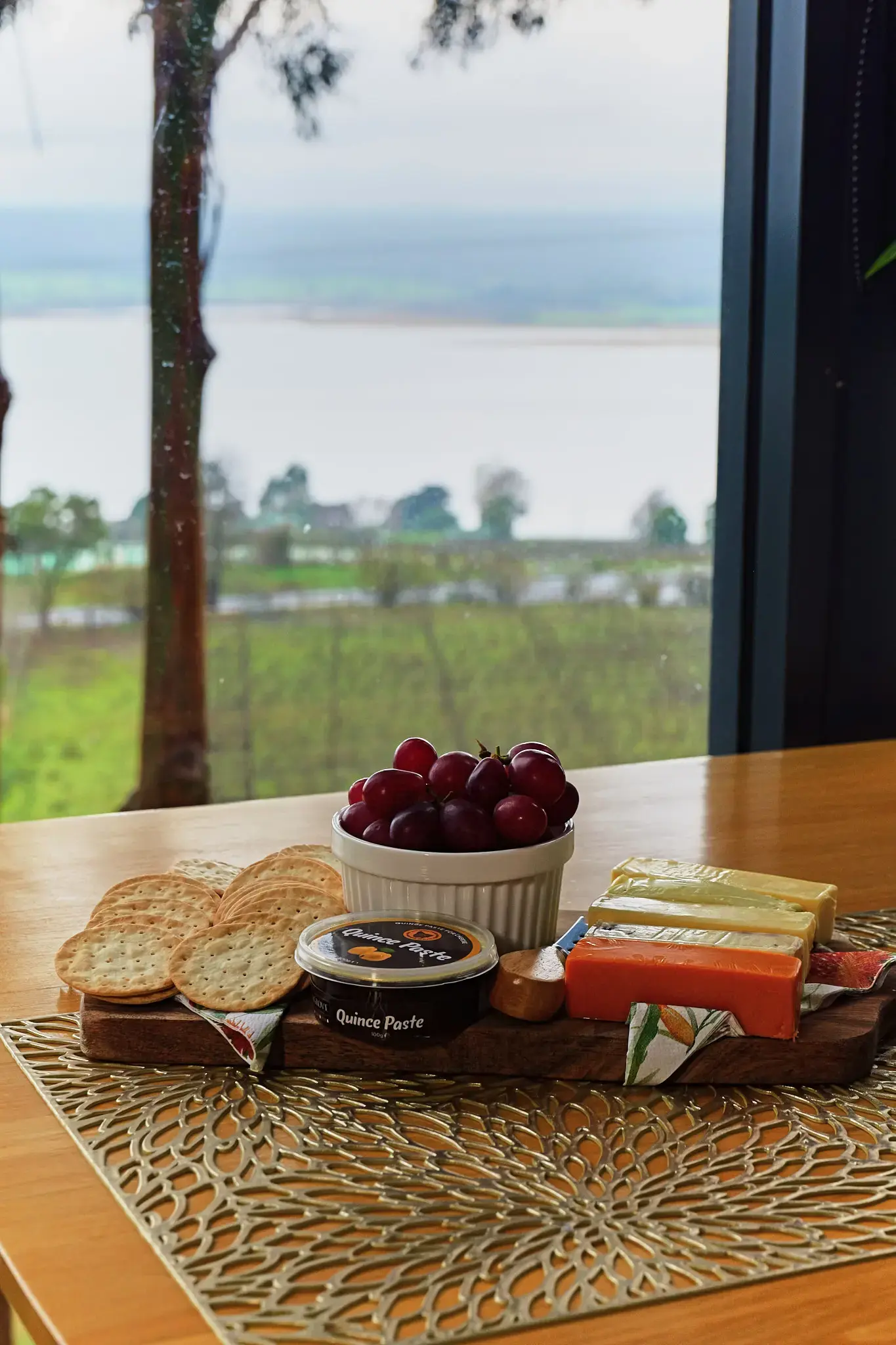 Cheese board with grapes and crackers by window