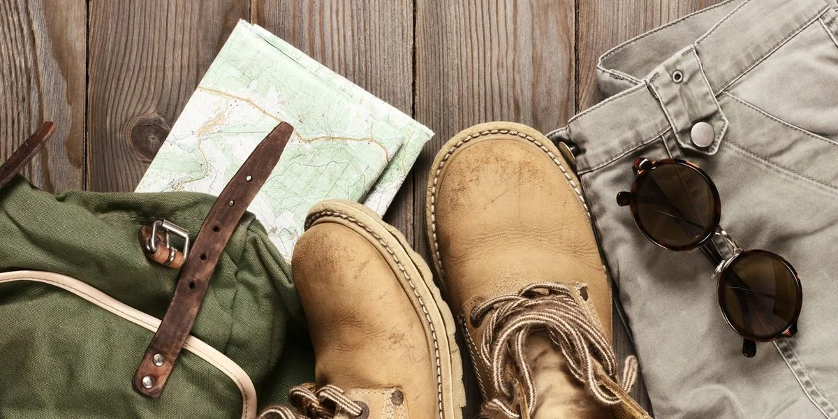 Adventure gear including boots, map, and sunglasses.