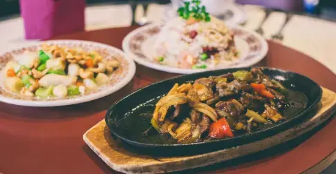 Sizzling stir-fry on hot plate with side dishes