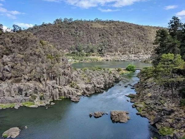 Serene river flowing through rocky landscape.