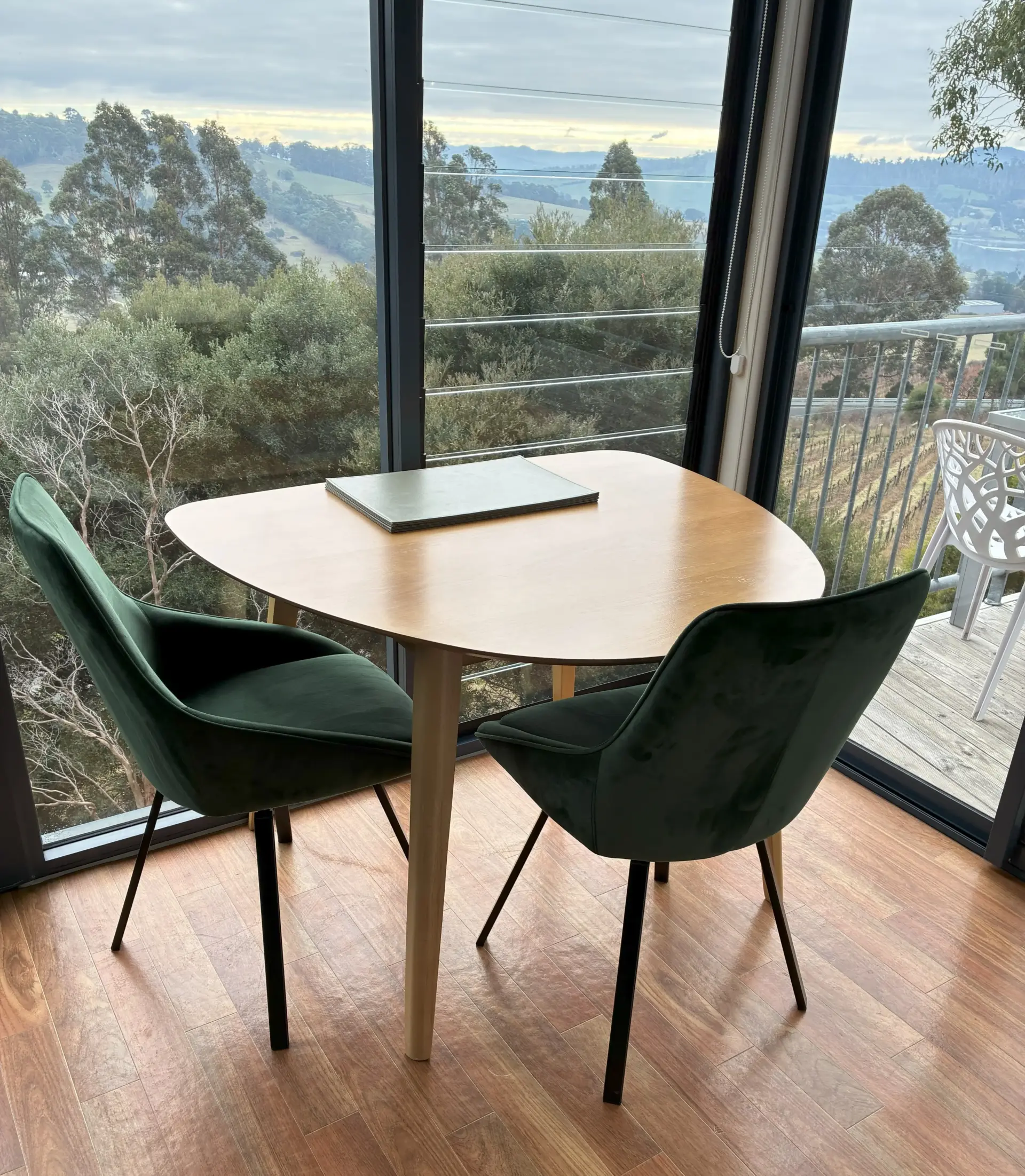 Table and chairs overlooking scenic countryside hills